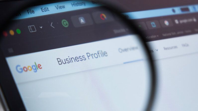 Google Business Profile logo on the screen of laptop through magnifying glass,