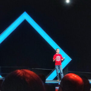 Man getting ready to climb up mountain looking up at the challenge before him planning path.